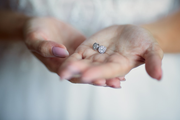 bride-holds-silver-earrings-her-arms_8353-8672